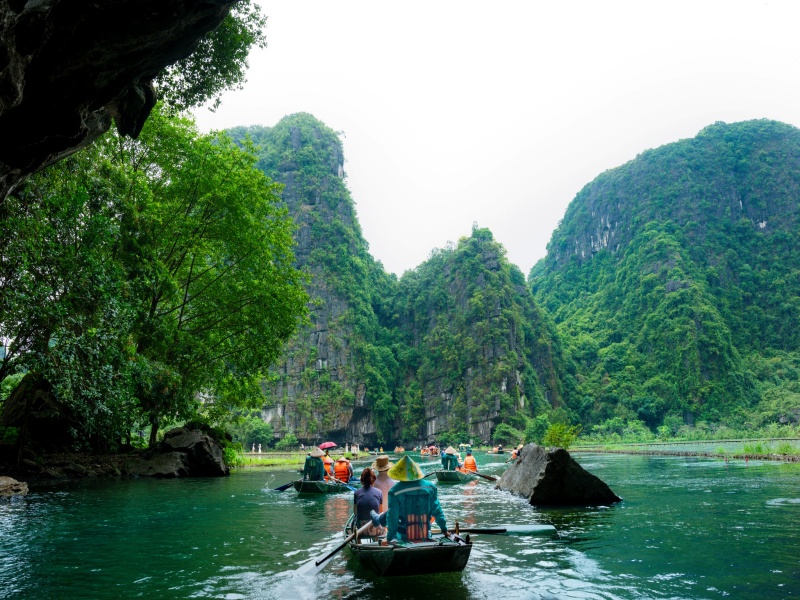 Feel Tam Coc's local pulse: natural foot-rowers, vendor chats, daily riverside scenes—pure, personal vibe
