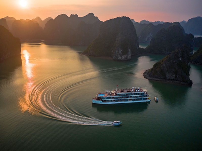 As night falls, cruises stop in peaceful waters surrounded by limestone.