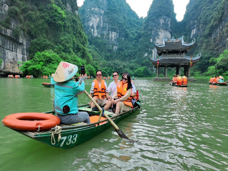 trang an sampan boat entering dark cave grotto ninh binh vietnam