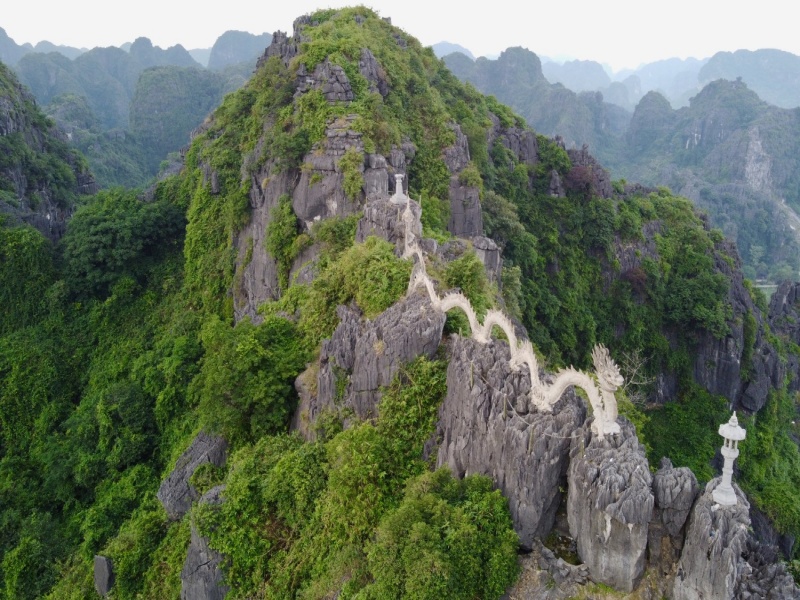 Stone Dragon and Pagoda at the Mua Cave's Summit: Blending Landscape, Spirituality, and Royal History