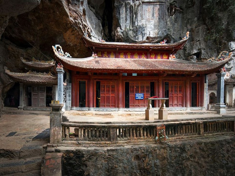 Trung Pagoda's cave core: Scented chill, altar against rock, ethereal glow through gaps.