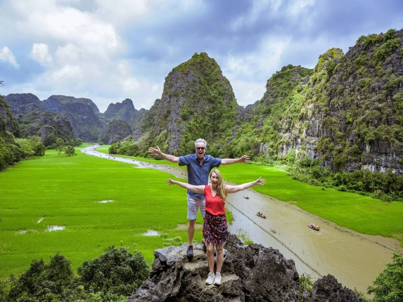 Ninh Binh in March—kapok flowers blaze red, fresh rice fields glow green, mild air feels magical.