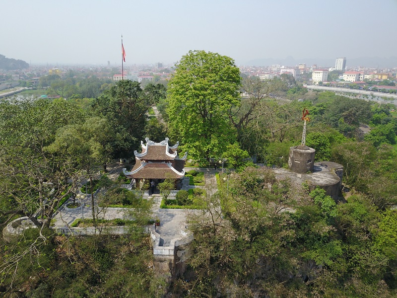 Gaze at the Day River snaking through Ninh Binh, rooftops fading to limestone peaks—serene city escape.